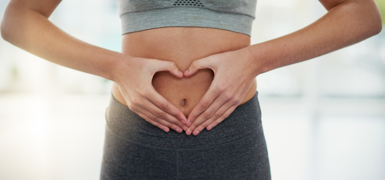 Women with hands in shape of love heart on stomach