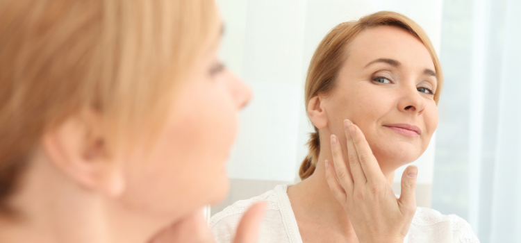 Lady looking in the mirror admiring her skin